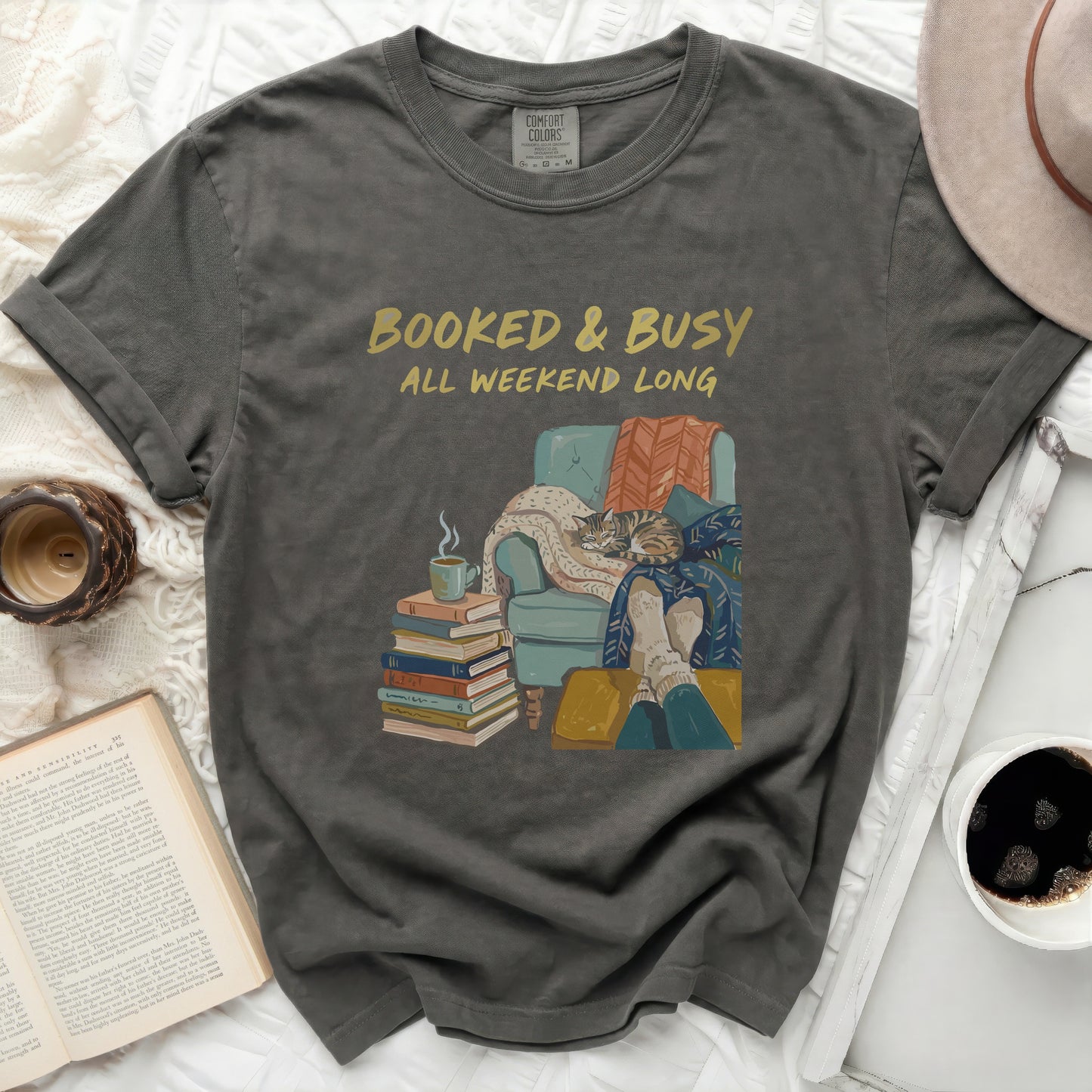 T-shirt with "Booked & Busy All Weekend Long" text and cozy reading scene.