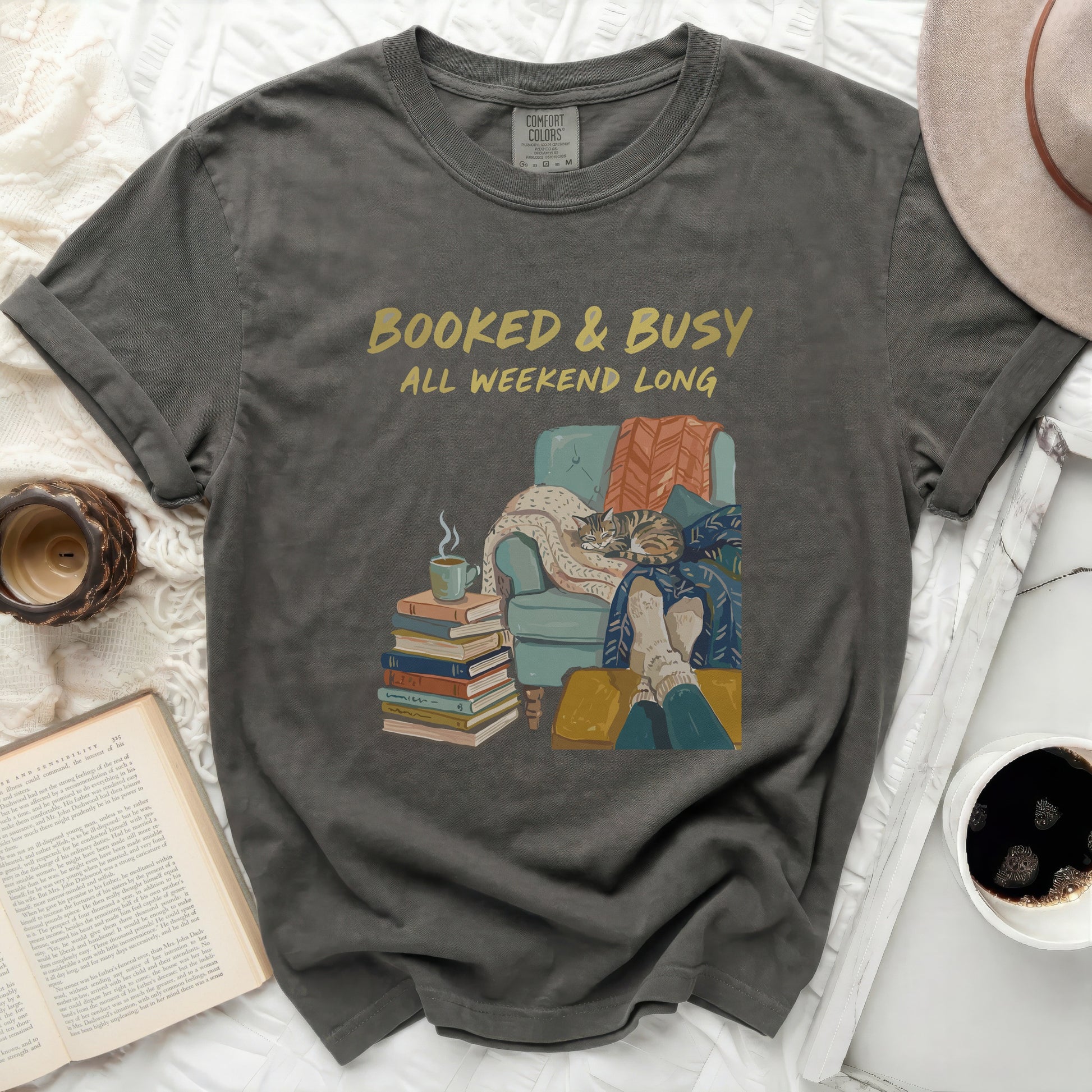 T-shirt with "Booked & Busy All Weekend Long" text and cozy reading scene.