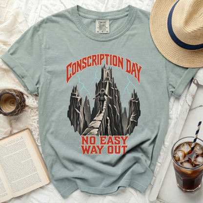 Sage green t-shirt featuring a graphic of a person walking a narrow bridge toward a distant castle under the text Conscription Day and No Easy Way Out.