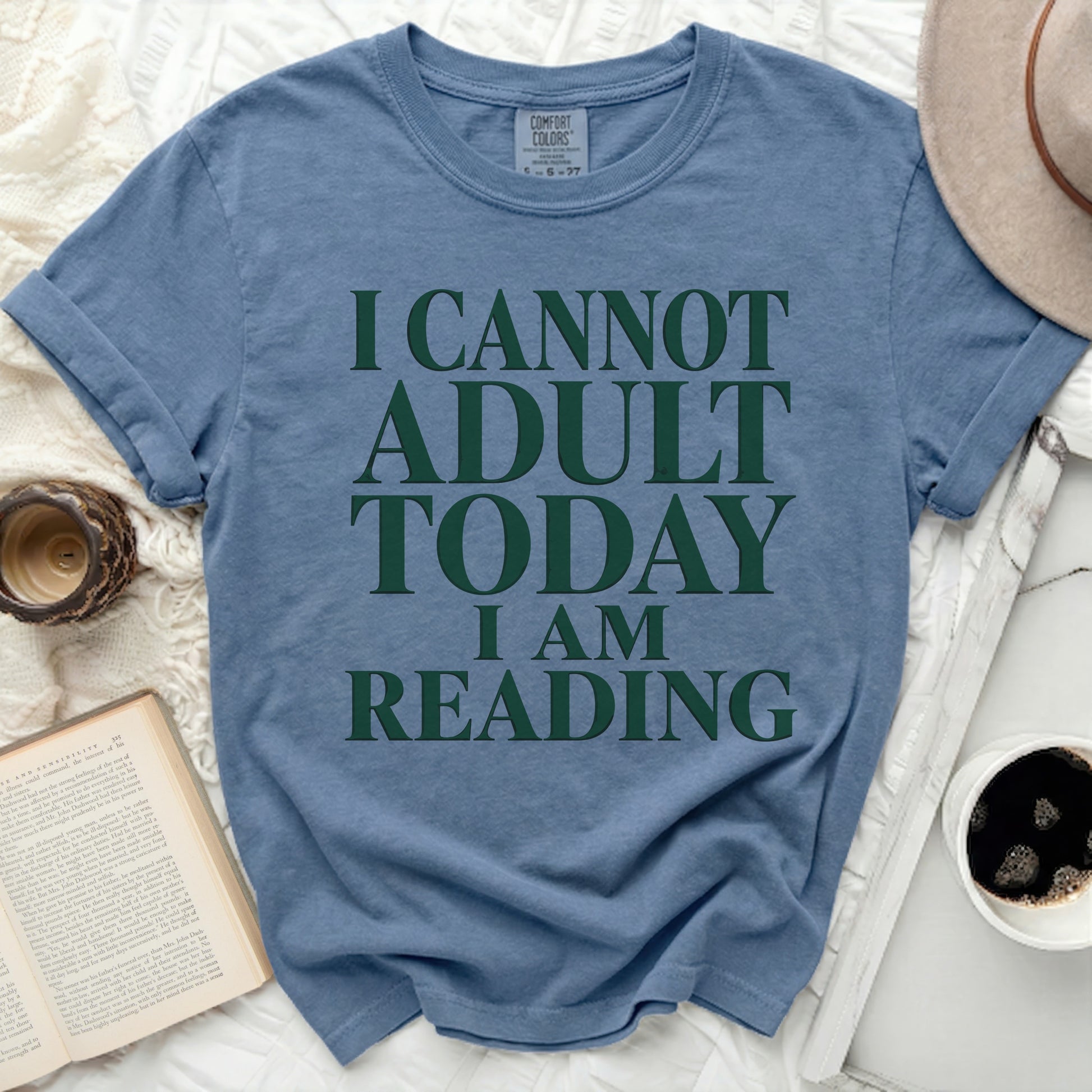 Blue t-shirt with "I CANNOT ADULT TODAY I AM READING" text.