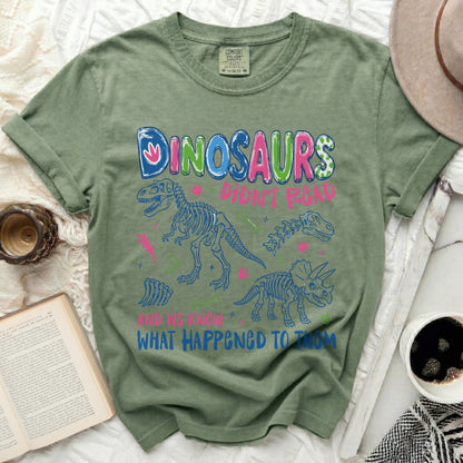 Green t-shirt with "Dinosaurs Didn't Read and We Know What Happened to Them" graphic.