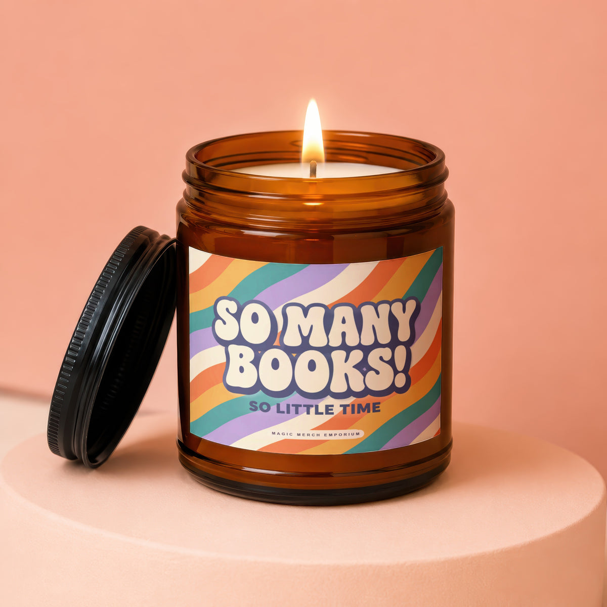 Amber jar candle with lit flame and lid, reads "So Many Books! So Little Time."