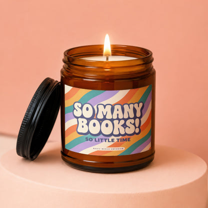 Amber jar candle with lit flame and lid, reads "So Many Books! So Little Time."