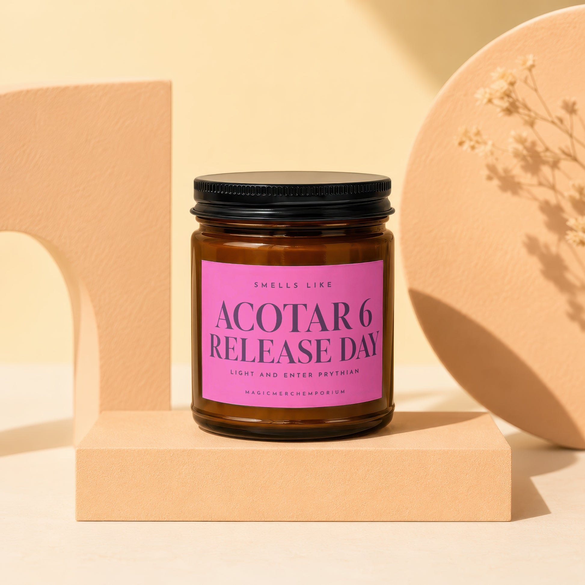 Amber jar candle with pink label reading "ACOTAR 6 RELEASE DAY" and "MAGICMERCHMEUPORIUM."