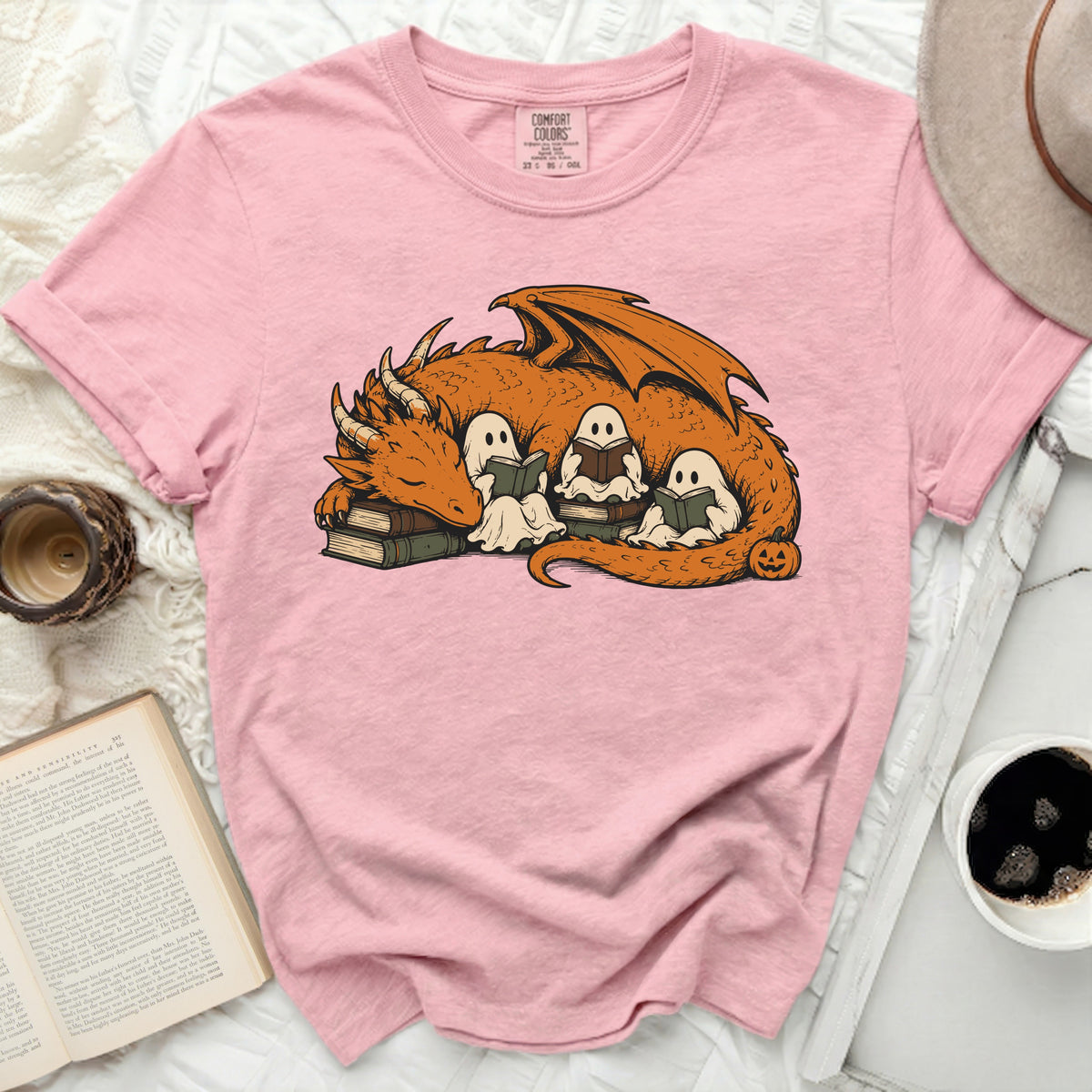 Pink t-shirt with dragon and ghosts reading books graphic.