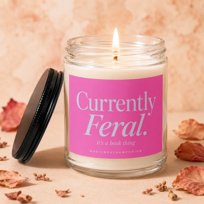 Candle with pink label reading "Currently Feral. it's a book thing"