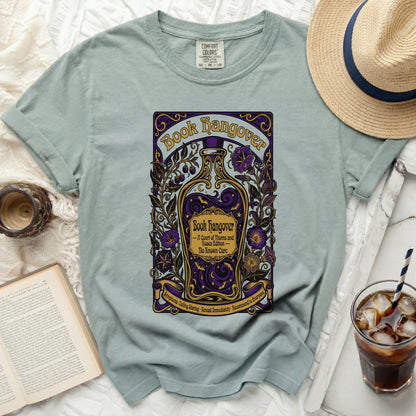 A light teal t-shirt with a "Book Hangover" graphic featuring a potion bottle.