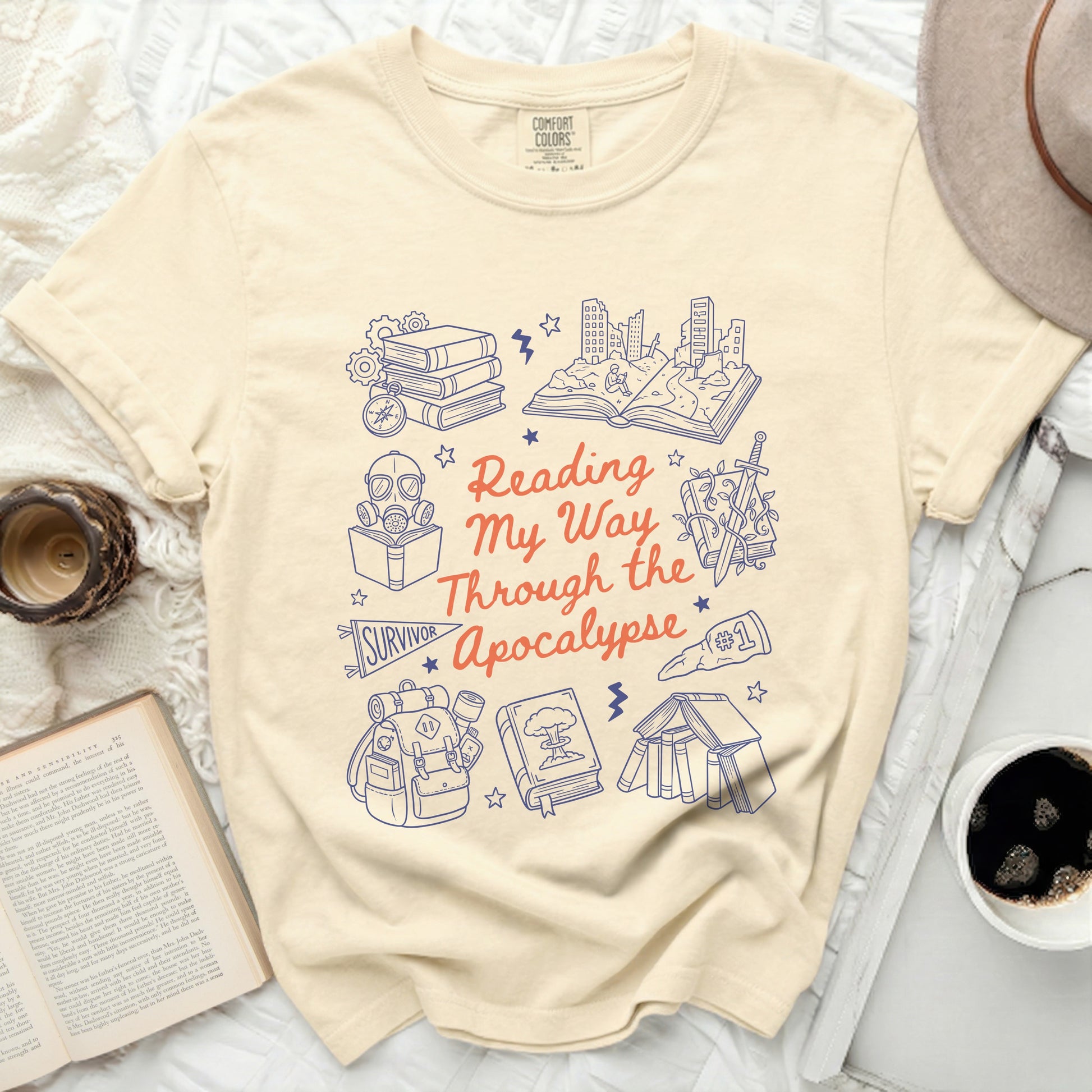 Cream t-shirt with "Reading My Way Through the Apocalypse" text and illustrations.