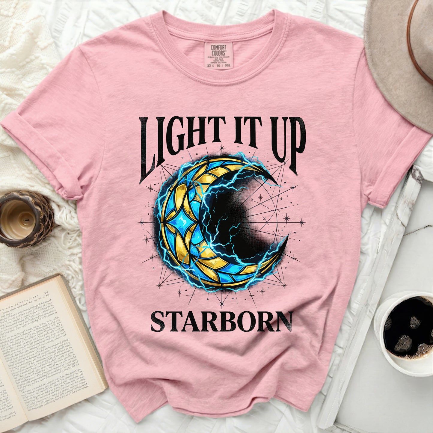 Pink t-shirt with a celestial crescent moon graphic and "Light It Up Starborn" text.