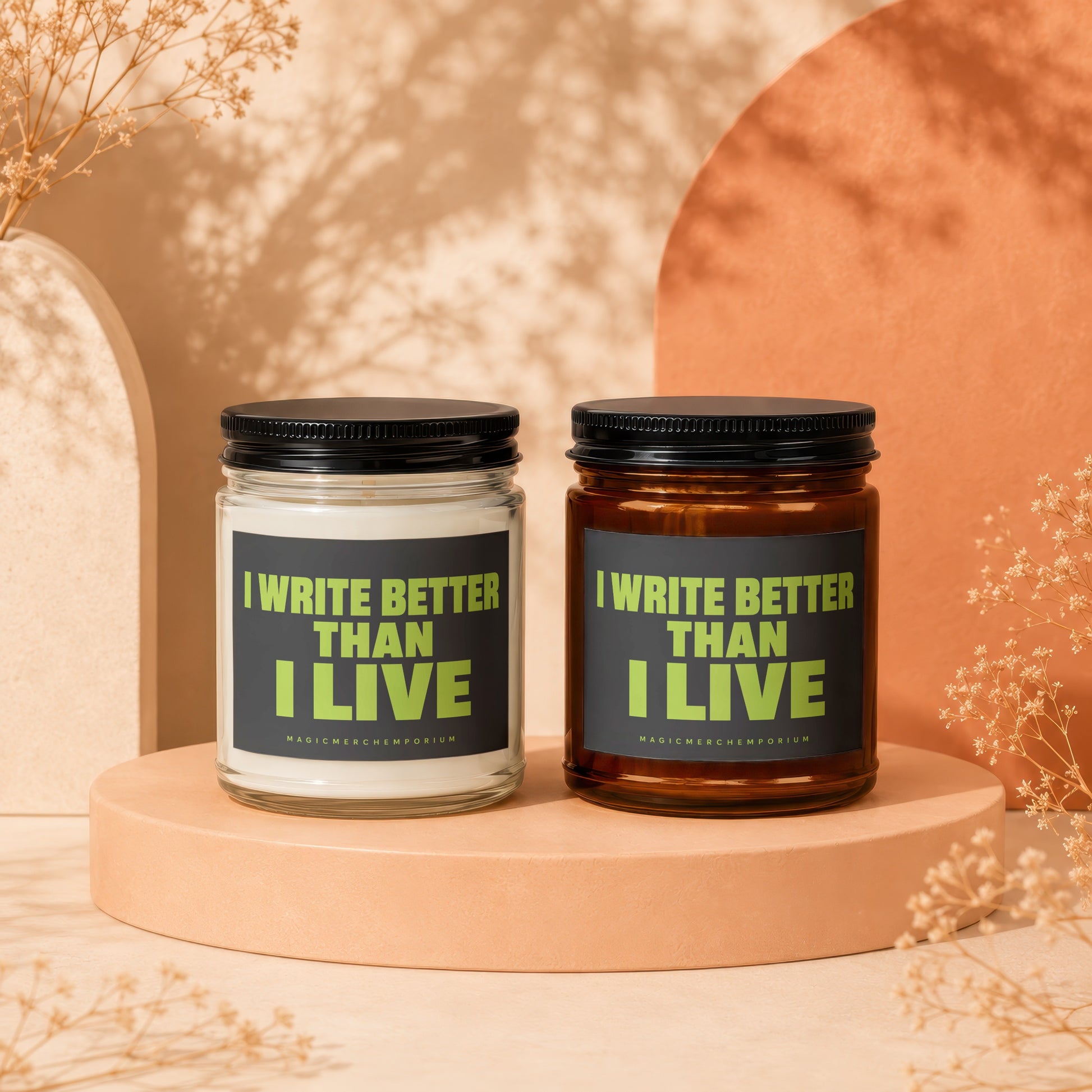 Two candles with "I WRITE BETTER THAN I LIVE" text on dark labels.