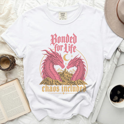 White t-shirt with pink dragons, castle, and text "Bonded for Life, chaos included".