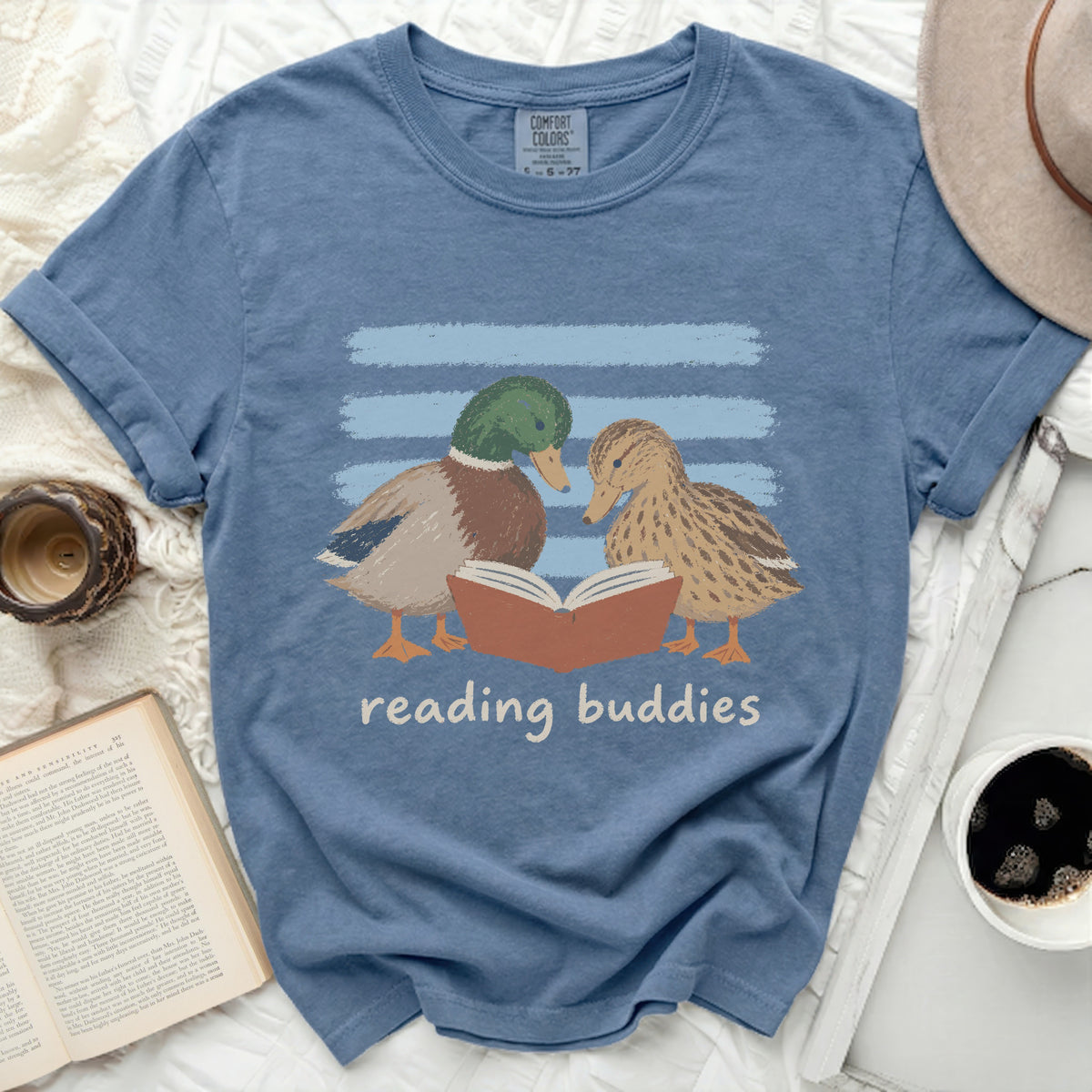 Blue t-shirt with graphic of two ducks reading a book and text reading "reading buddies".