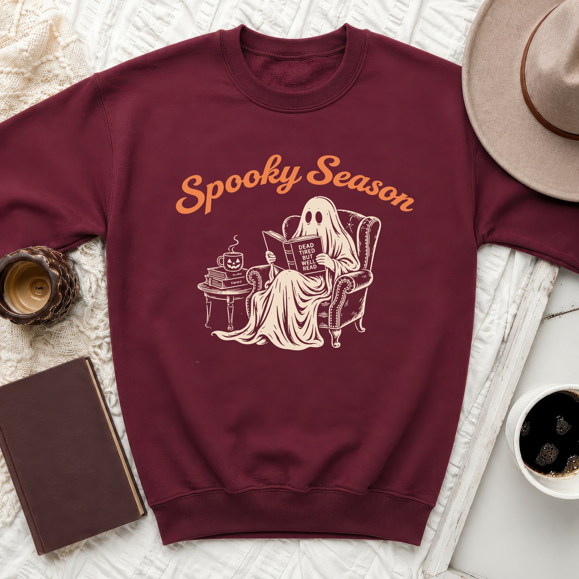 Maroon sweatshirt with a ghost reading a book that says "Dead tired but well read."