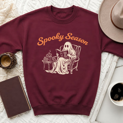 Maroon sweatshirt with a ghost reading a book that says "Dead tired but well read."