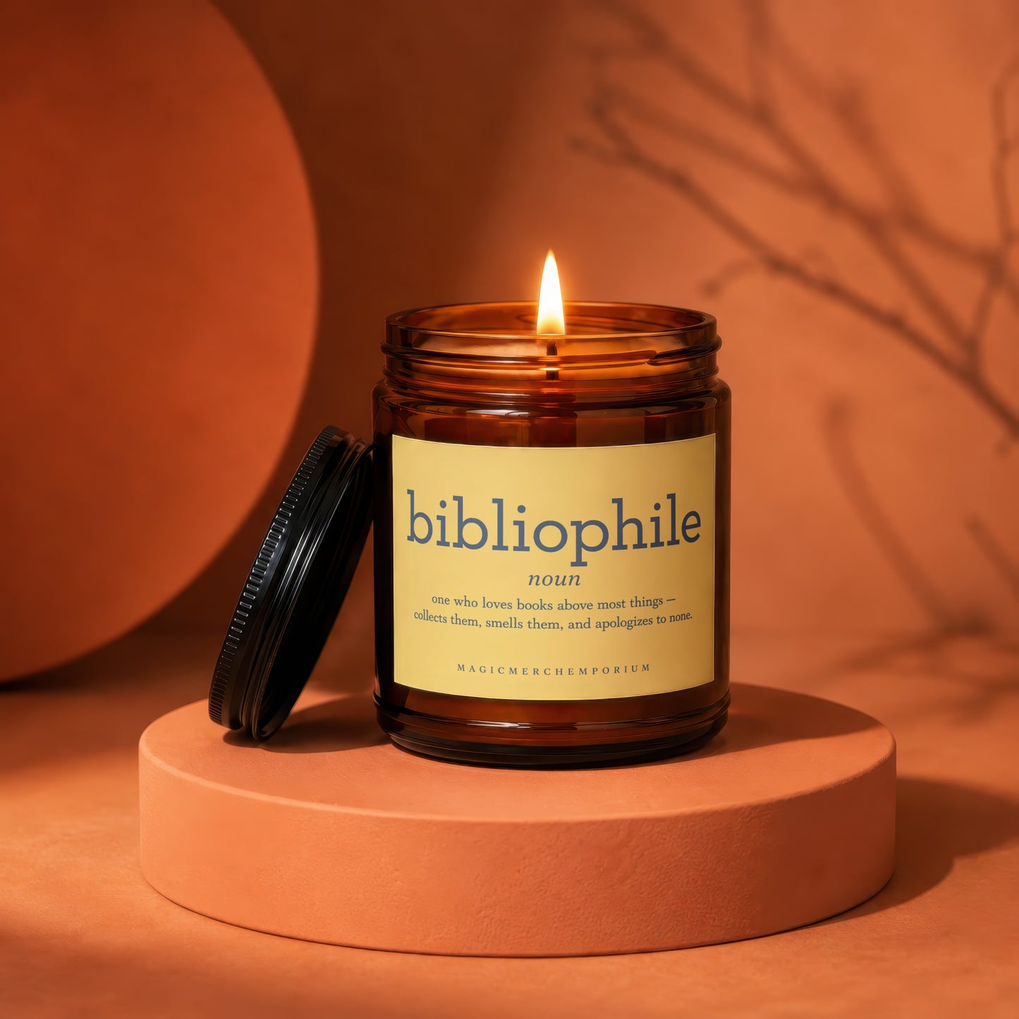 Lit bibliophile candle in amber glass jar with definition text on label.
