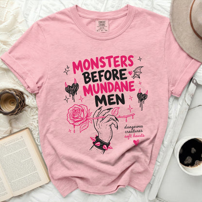 Pink t-shirt with "Monsters Before Mundane Men" text and rose graphic.