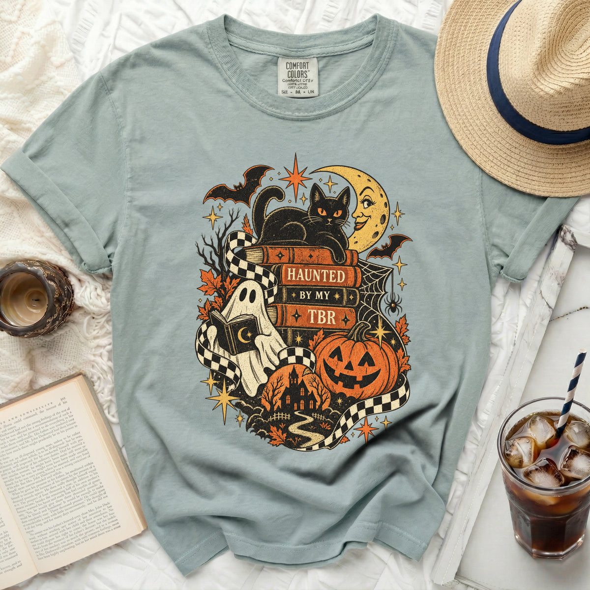 Comfort Colors shirt with Halloween print of black cat, ghost, pumpkin, and haunted house.