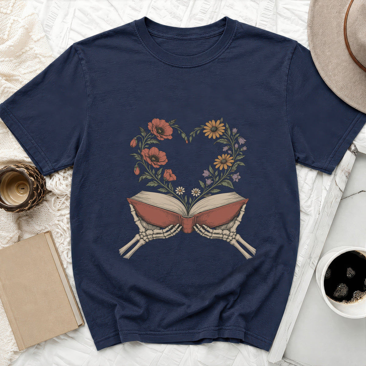 Navy t-shirt with skeleton hands holding an open book with flowers forming a heart.