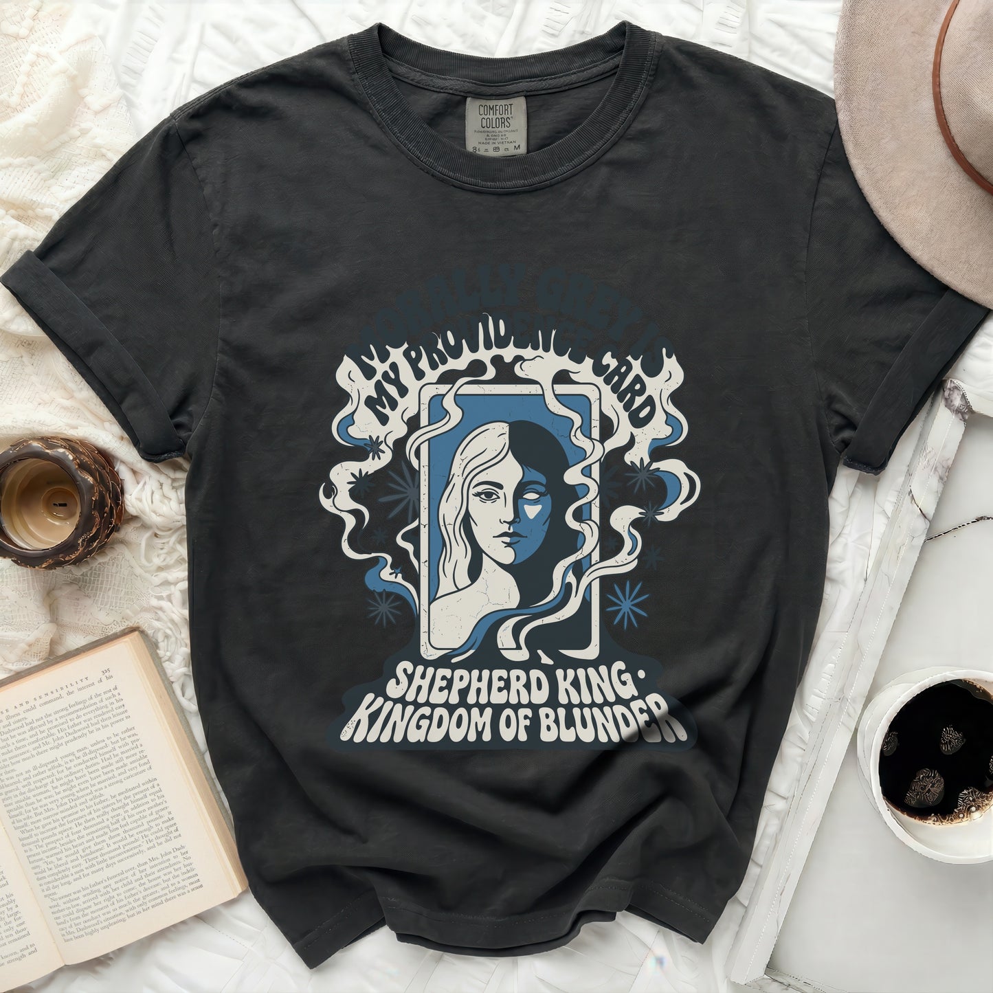 T-shirt with "Shepherd King Kingdom of Blunder" text and distressed portrait.