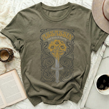 Olive t-shirt with "Assassin but Make It Healing" text and floral sword graphic.