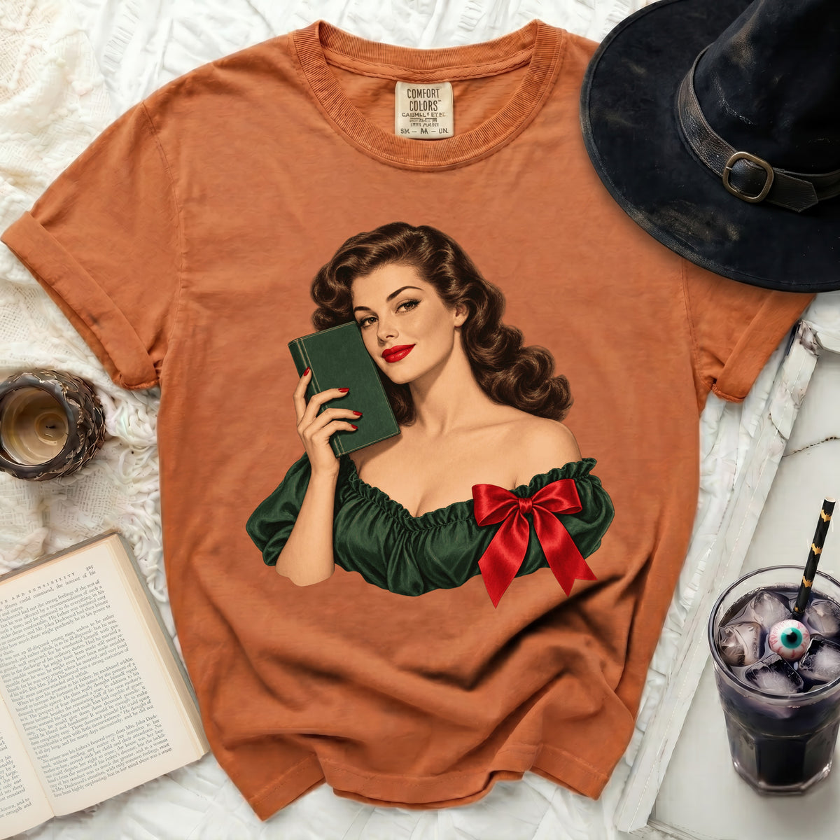 Orange Comfort Colors t-shirt with vintage pin-up graphic holding a book.
