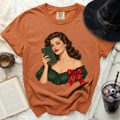 Orange Comfort Colors t-shirt with vintage pin-up graphic holding a book.
