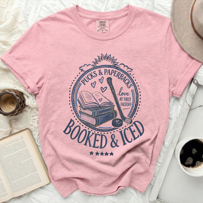 Pink t-shirt with "Booked & Iced" graphic featuring books and hockey stick.