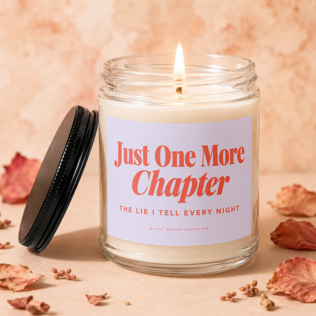 Burning glass jar candle with label reading "Just One More Chapter"