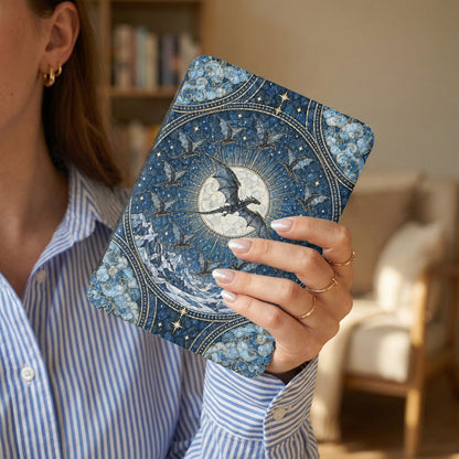 A person in a blue-and-white striped shirt holds a blue e-reader case featuring an intricate dragon and moon illustration.