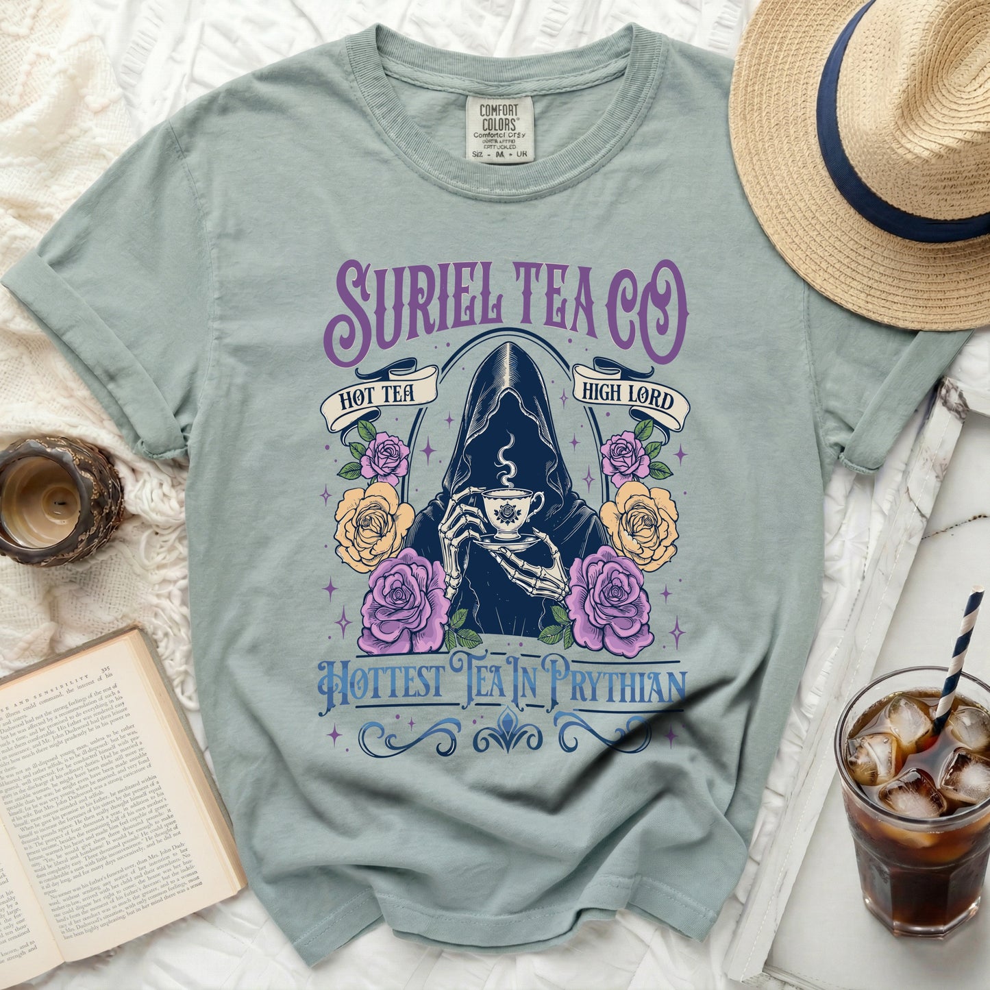 Light teal t-shirt with Suriel Tea Co. graphic featuring grim reaper holding tea and roses.