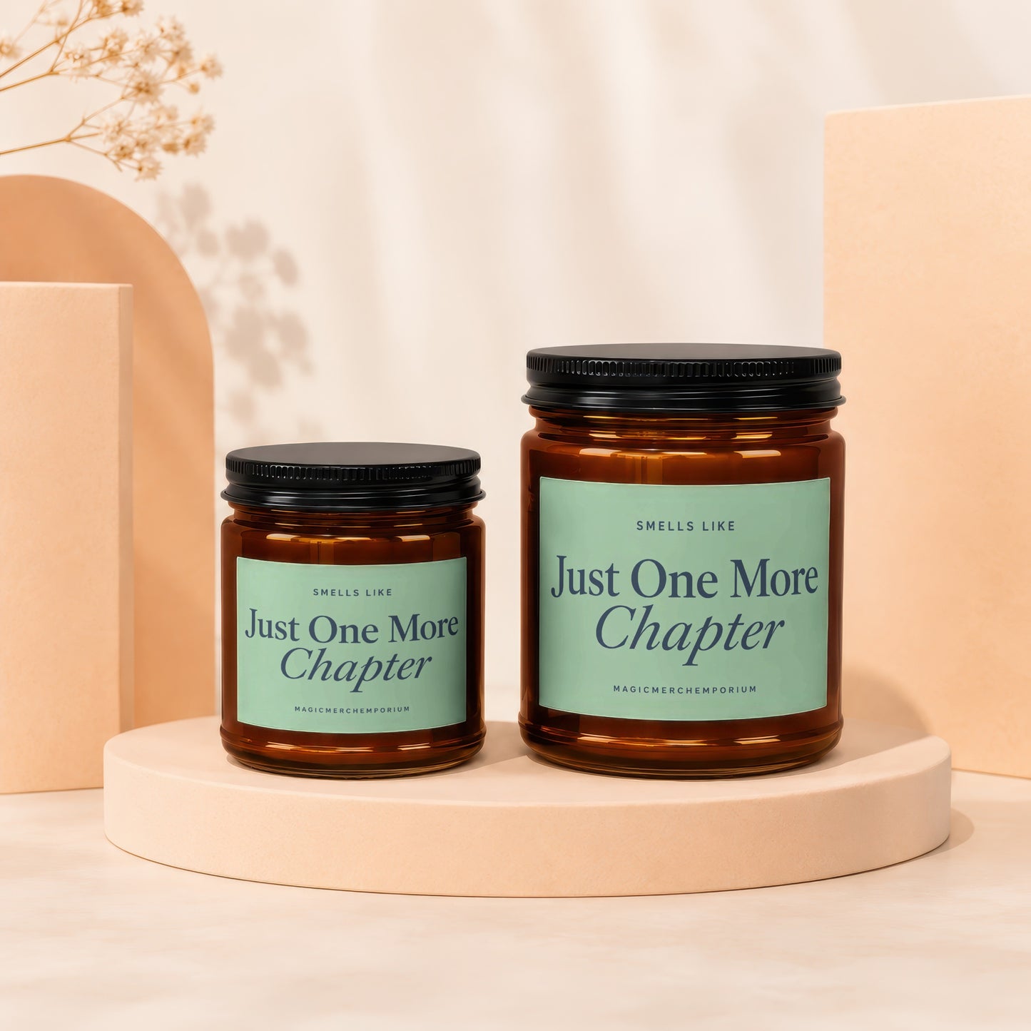 Two amber glass candles with green labels reading "Just One More Chapter".