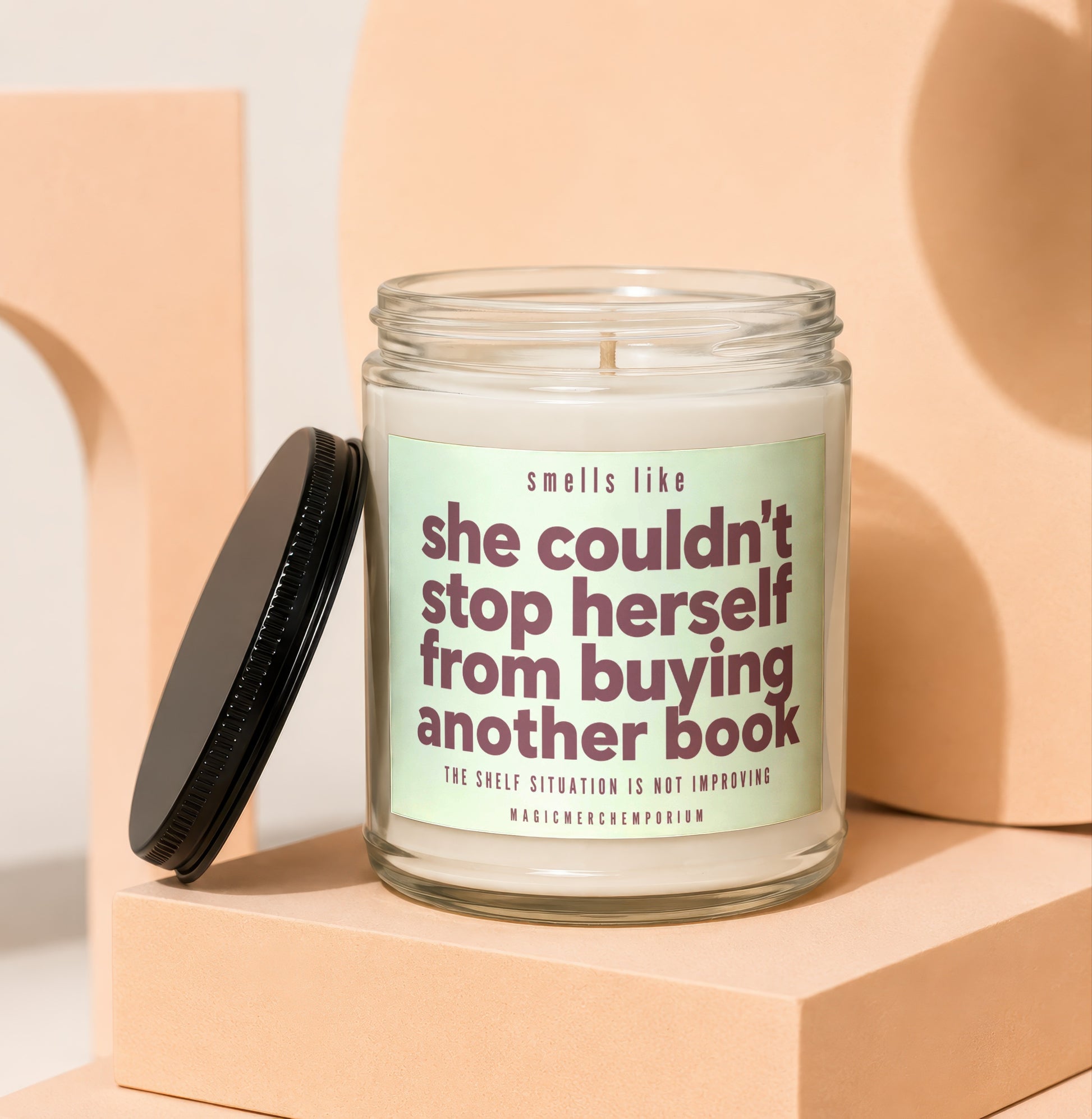 Candle with text: "smells like she couldn't stop herself from buying another book"