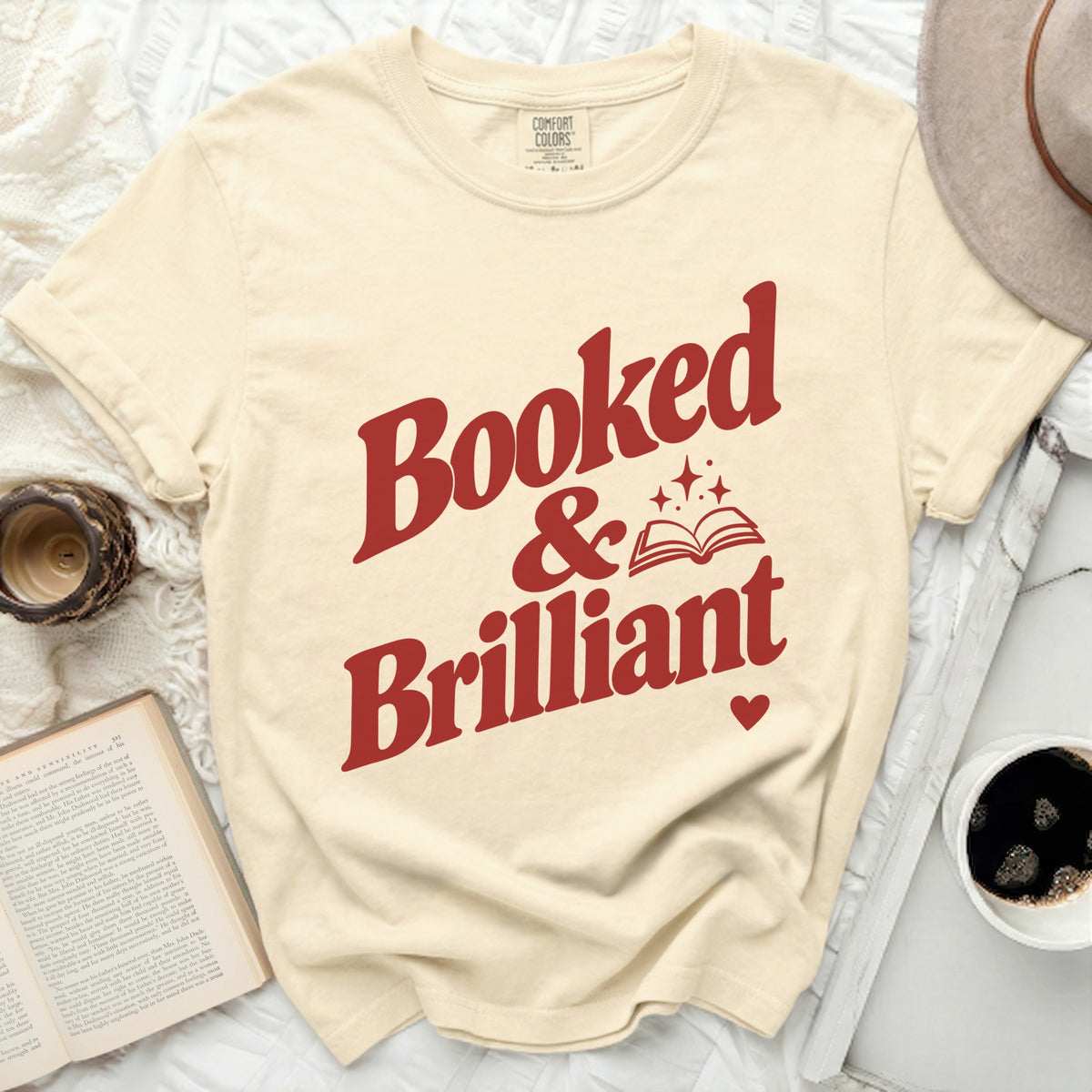 Cream t-shirt with red text "Booked & Brilliant" and an open book graphic.