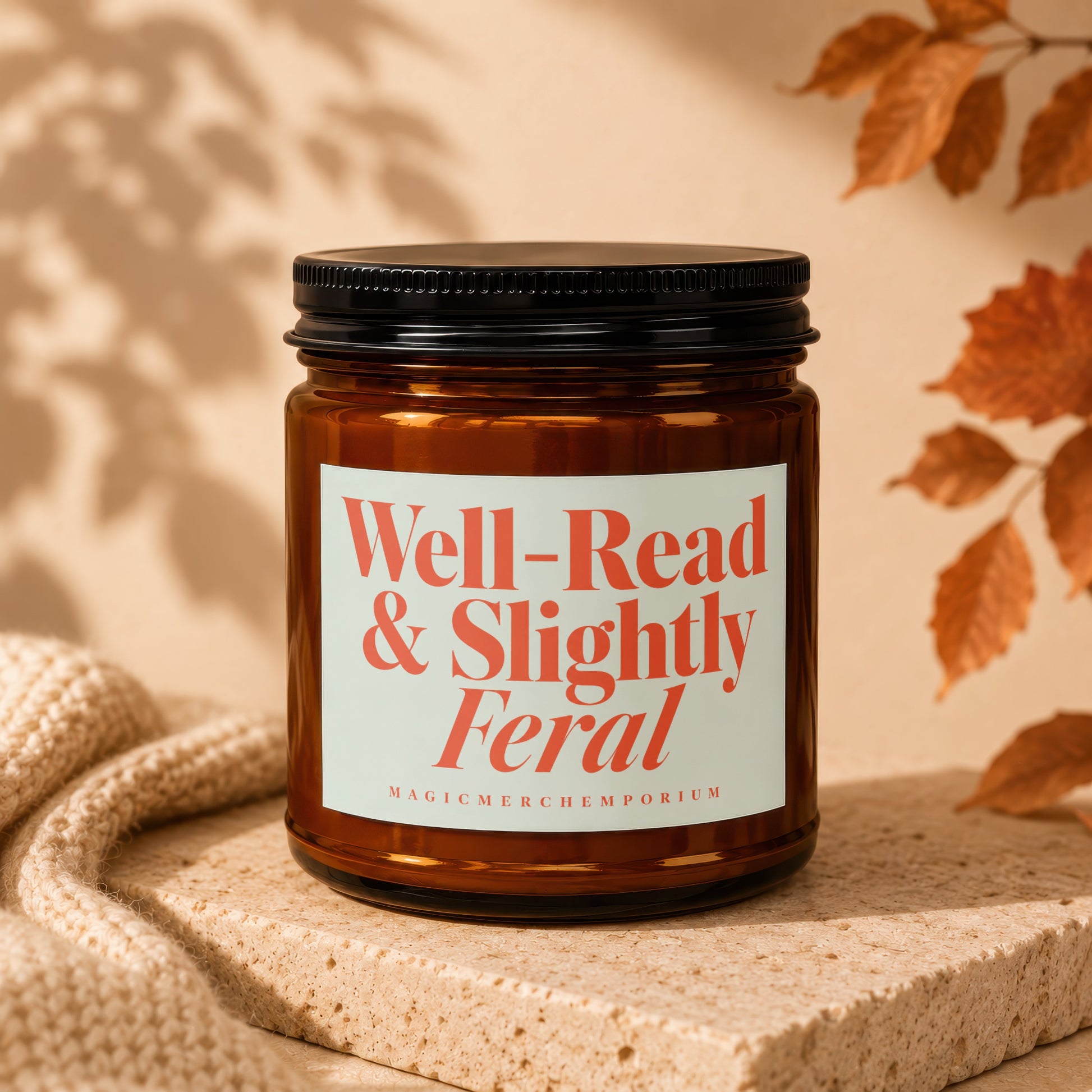 Amber candle with black lid, "Well-Read & Slightly Feral, MAGICMERCHIMPORIUM" label.