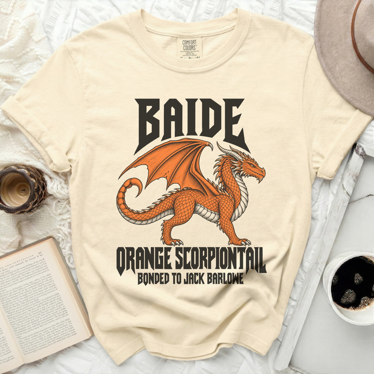 Cream t-shirt with an orange dragon graphic and text "BAIDE ORANGE SCORPIONTAIL BONDED TO JACK BARLOWE".