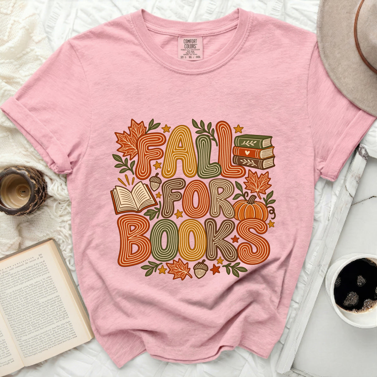Pink t-shirt with "FALL FOR BOOKS" graphic and autumn illustrations.