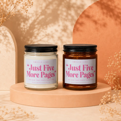 Two scented candles labeled "Just Five More Pages" with black lids.