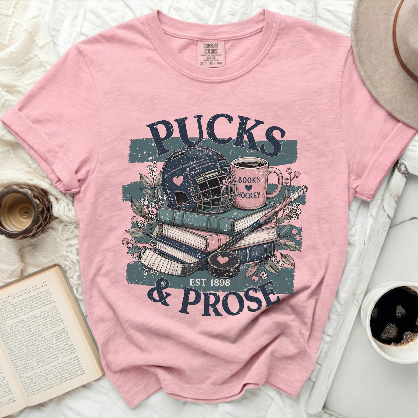 Pink t-shirt with "Pucks & Prose" hockey and book design.