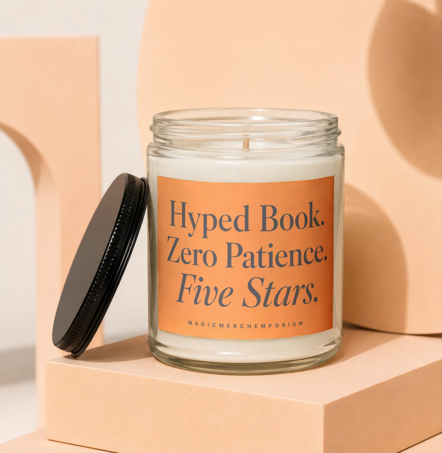Candle with orange label reading "Hyped Book. Zero Patience. Five Stars."
