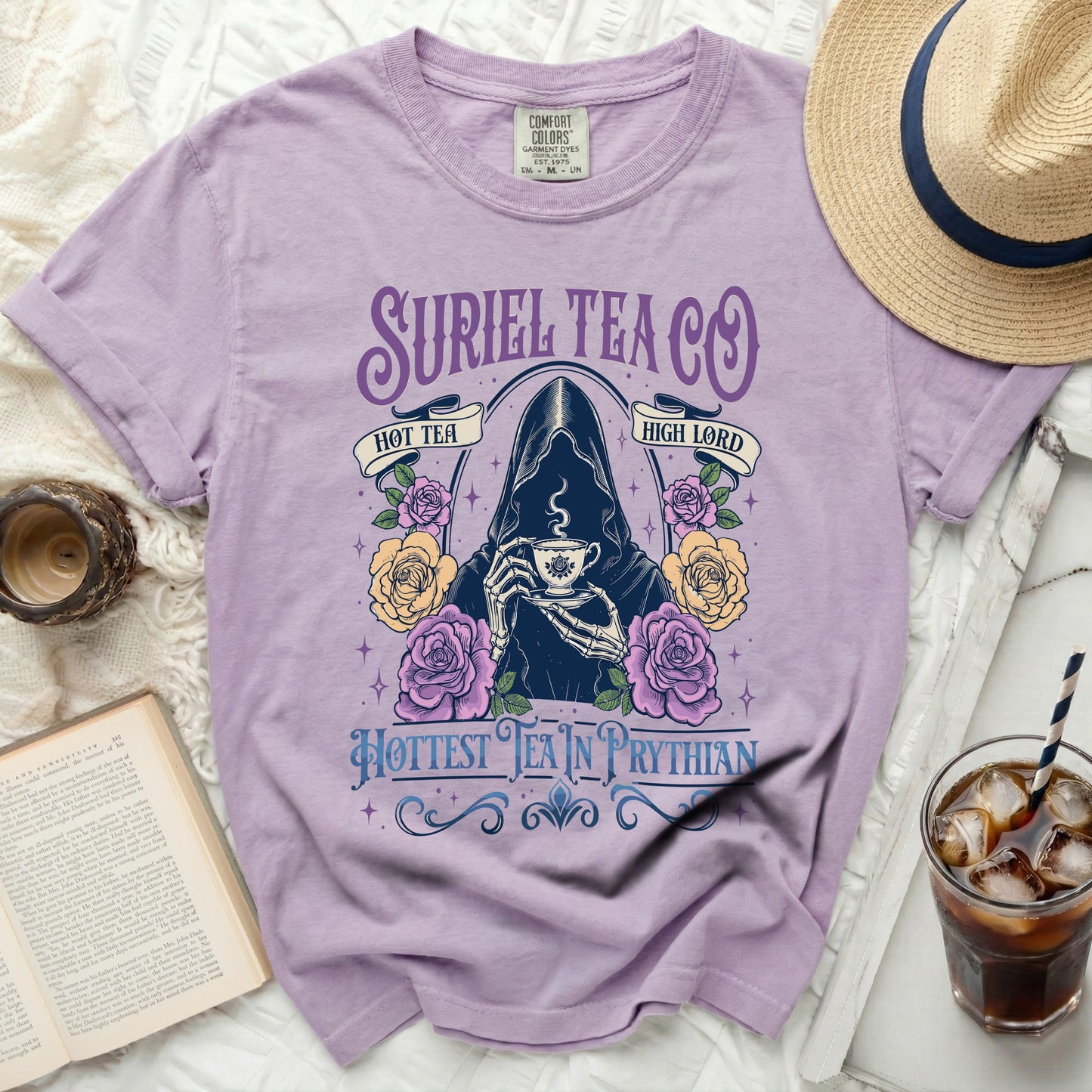 Purple t-shirt with grim reaper, roses, and "Suriel Tea Co." text.