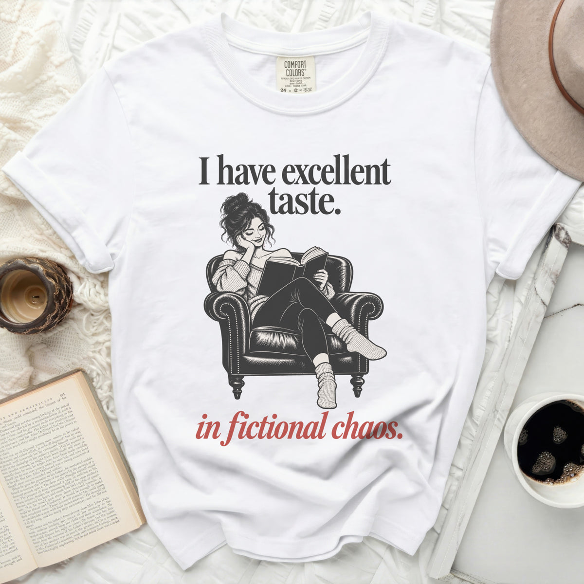 White t-shirt with "I have excellent taste. in fictional chaos." text and illustration.