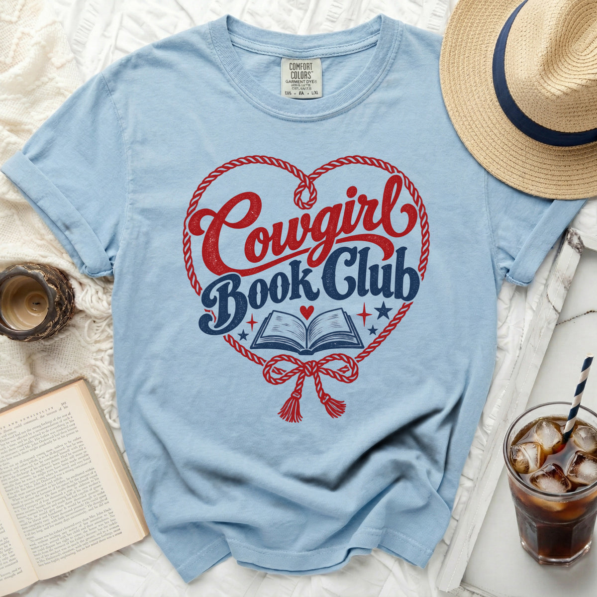Light blue t-shirt with red and blue "Cowgirl Book Club" graphic inside a rope heart.