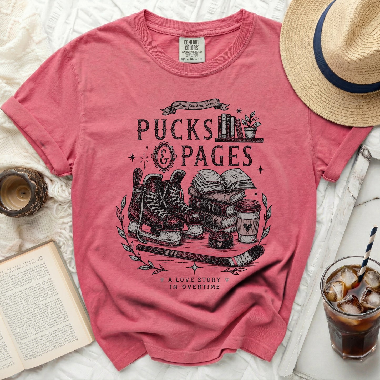 Pink t-shirt with "Pucks & Pages" and hockey illustration.