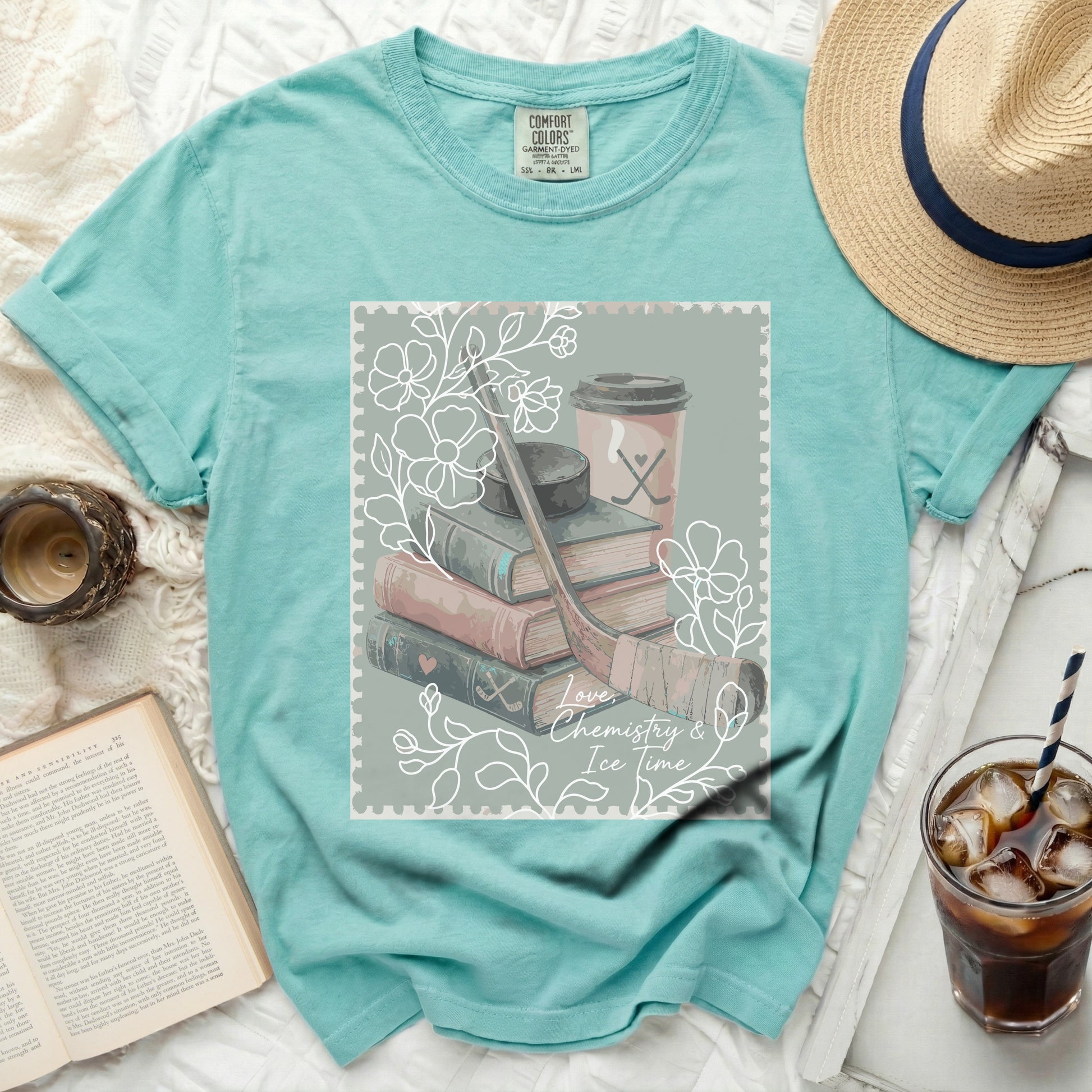 Aqua t-shirt with "Love, Chemistry & Ice Time" graphic featuring books and hockey gear.