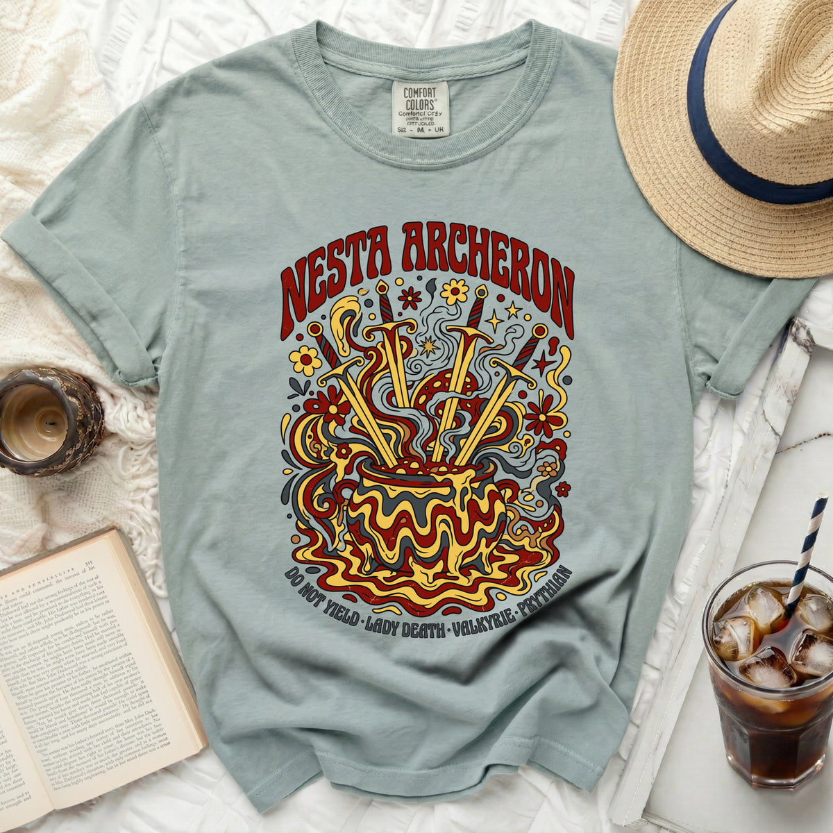 Nesta Archeron shirt with swords in a cauldron and floral design.