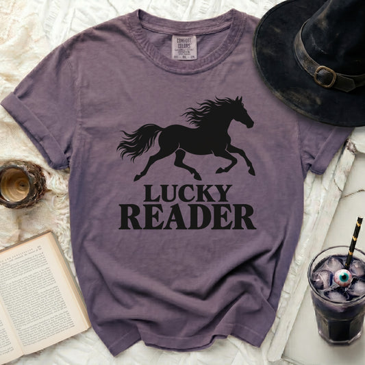 Purple t-shirt with black silhouette of running horse and text "LUCKY READER".
