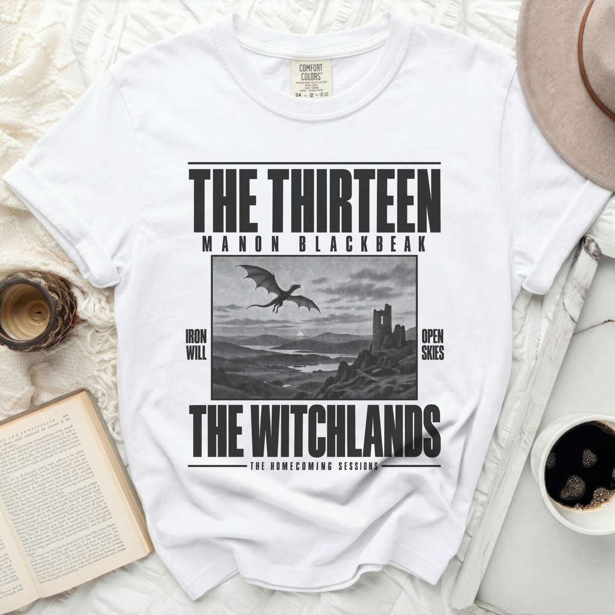 White t-shirt with black text and dragon graphic: "The Thirteen Manon Blackbeak"