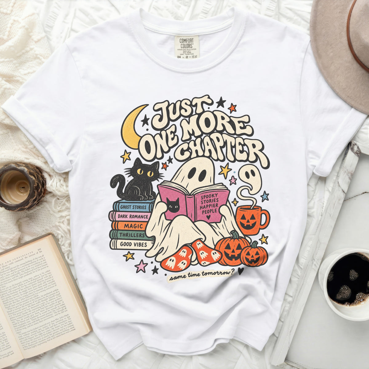 White t-shirt with "Just One More Chapter" graphic featuring a ghost reading.