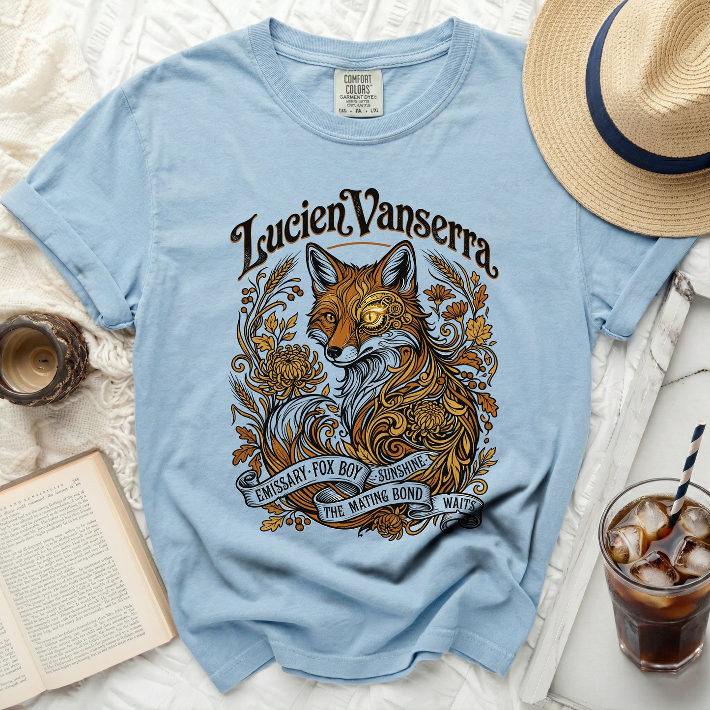 Light blue t-shirt with ornate fox, floral, and banner graphic and text.