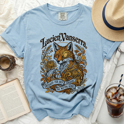 Light blue t-shirt with ornate fox, floral, and banner graphic and text.